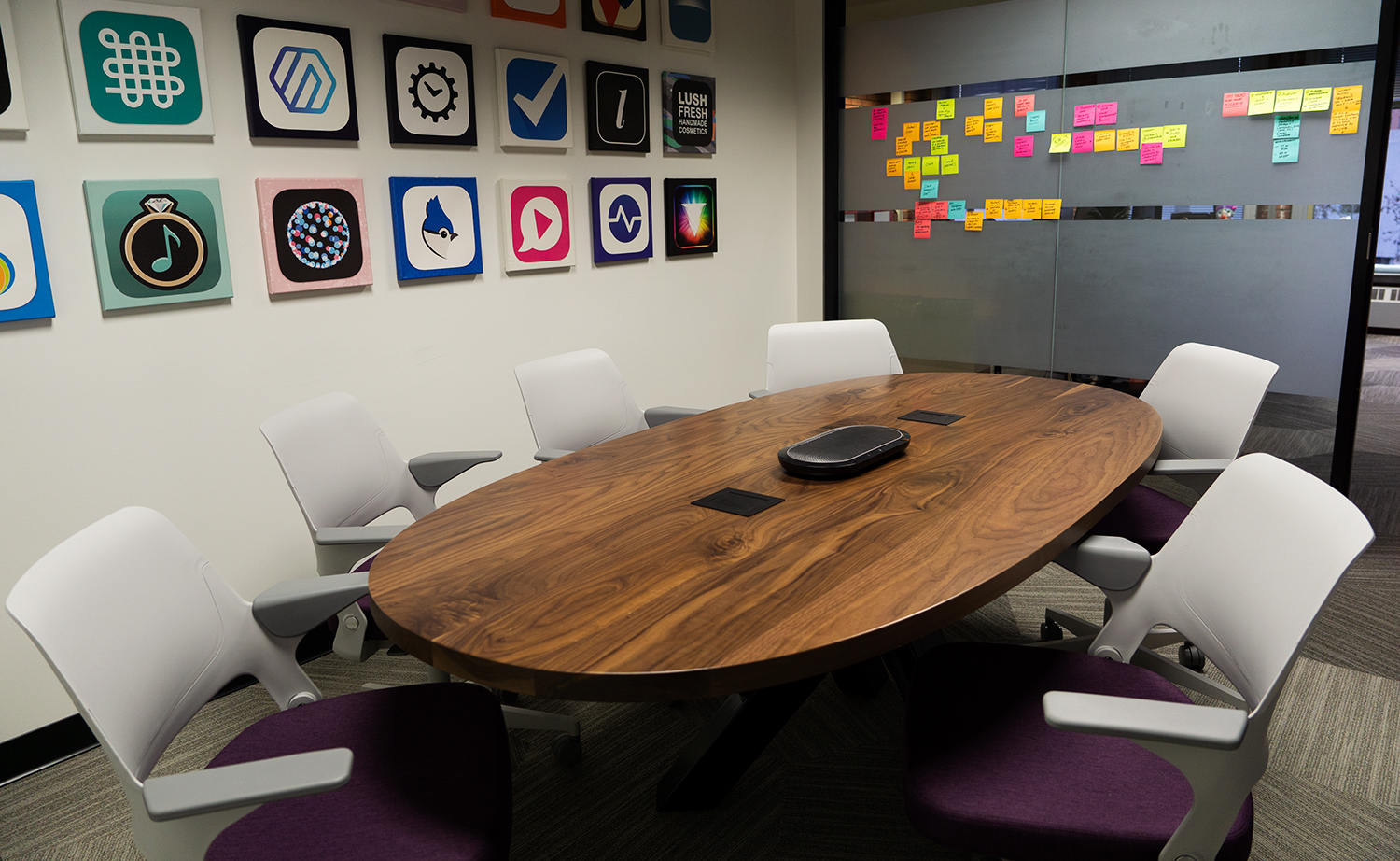 Our empty meeting room at the Steamclock office with our built app's icons on the wall and colorful stickynotes by the door